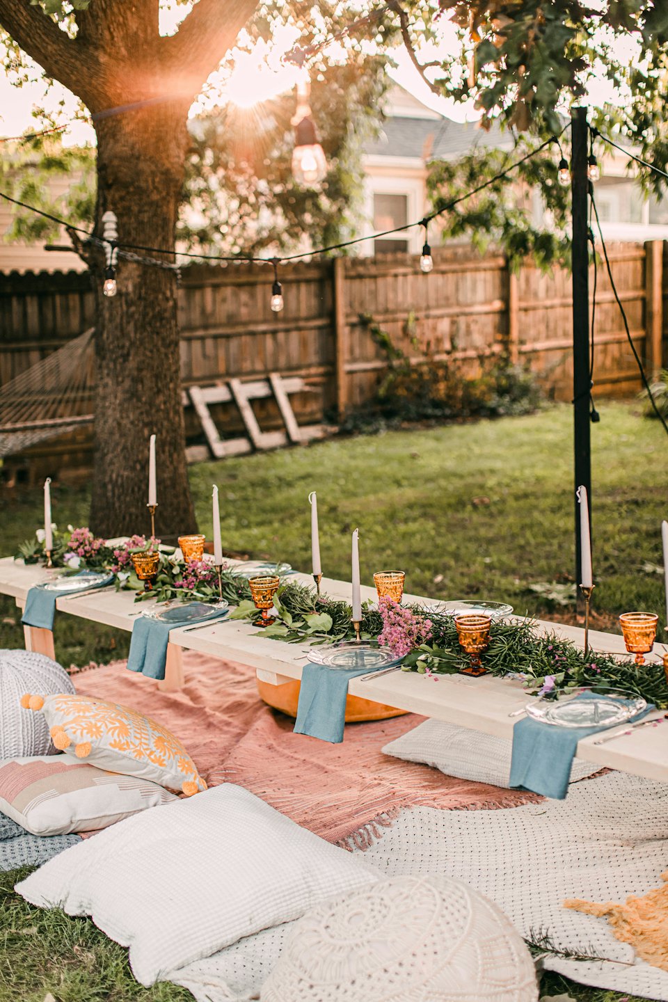 Outdoor table set with flowers for a gathering.