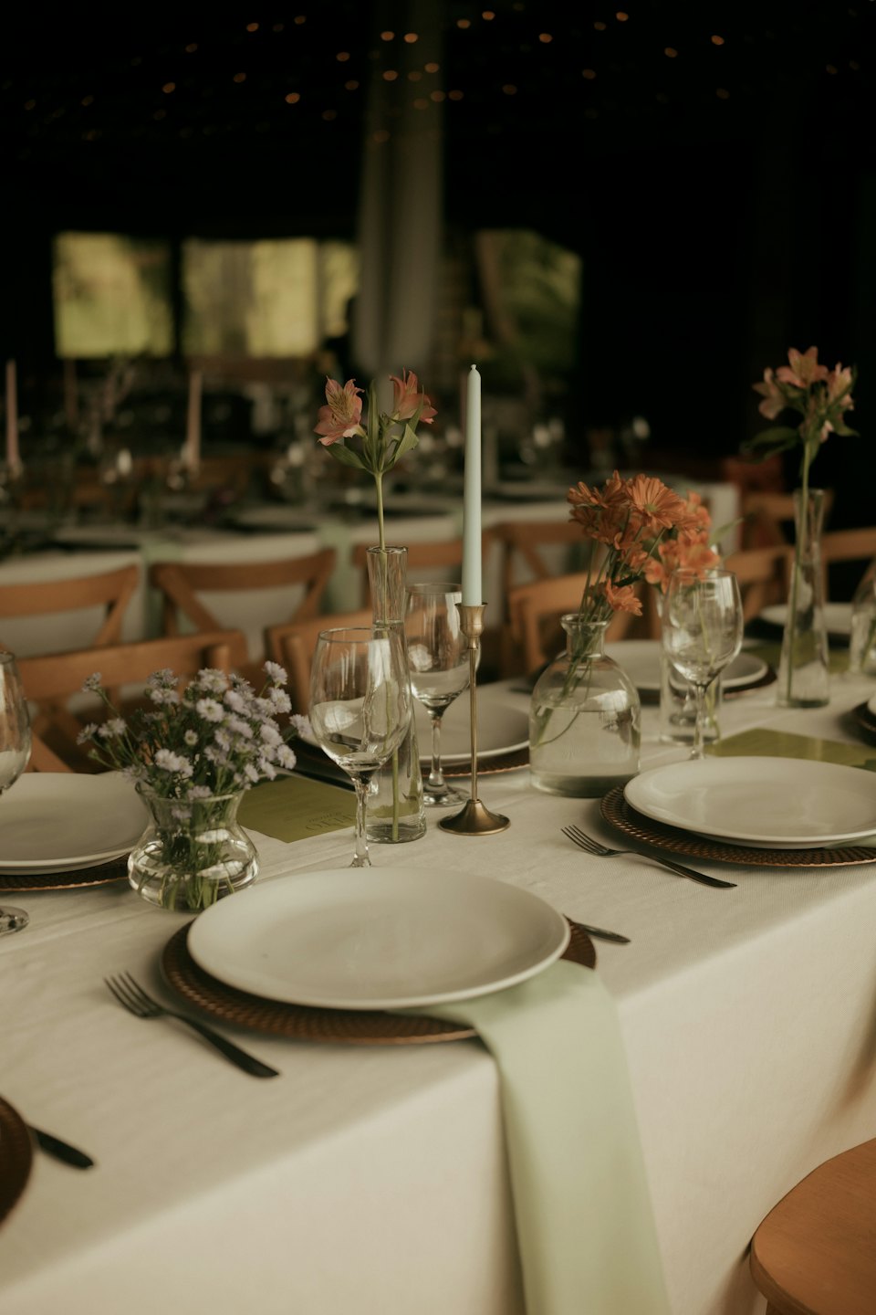 An elegant event table set with plates, napkins, and flowers.