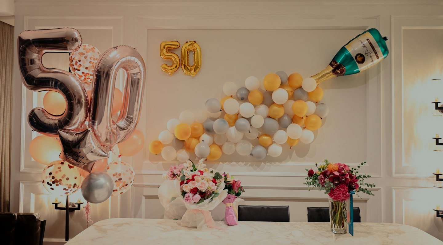 Rose gold 50 balloons and champagne bottle balloon arrangement.