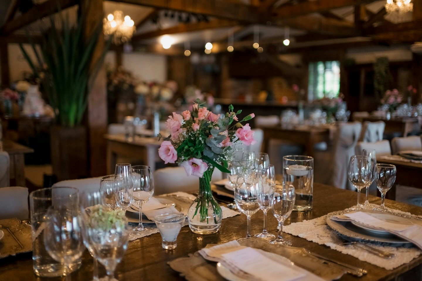 A dining table is set with floral centerpiece and linens.
